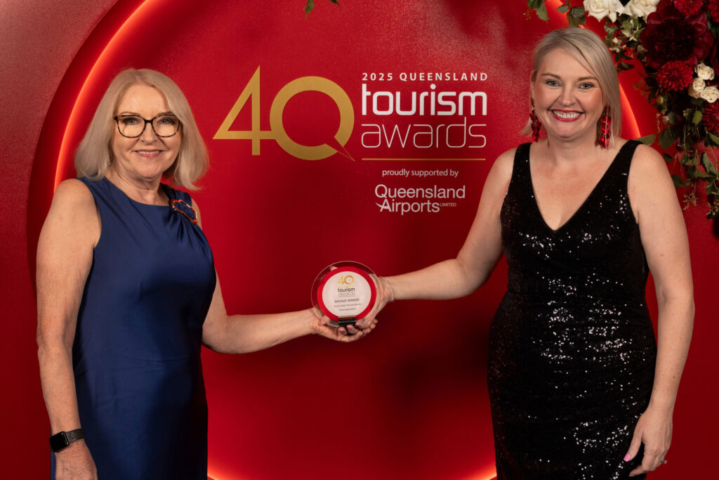 Two women stand in front of a 