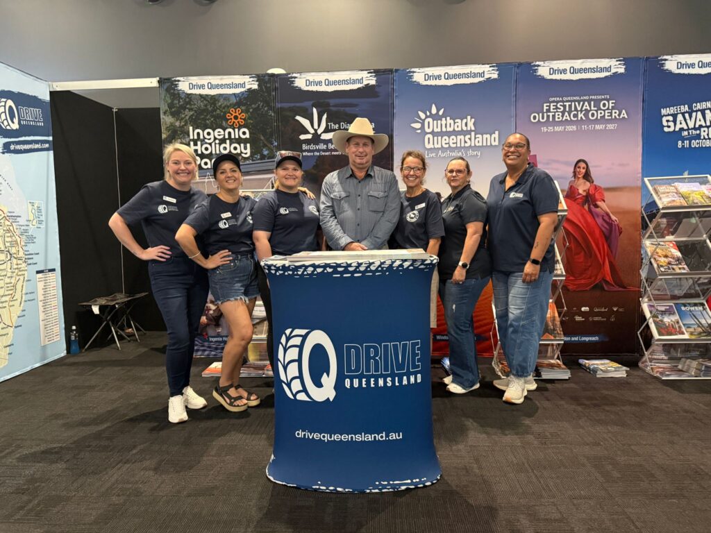 Seven people stand behind a 